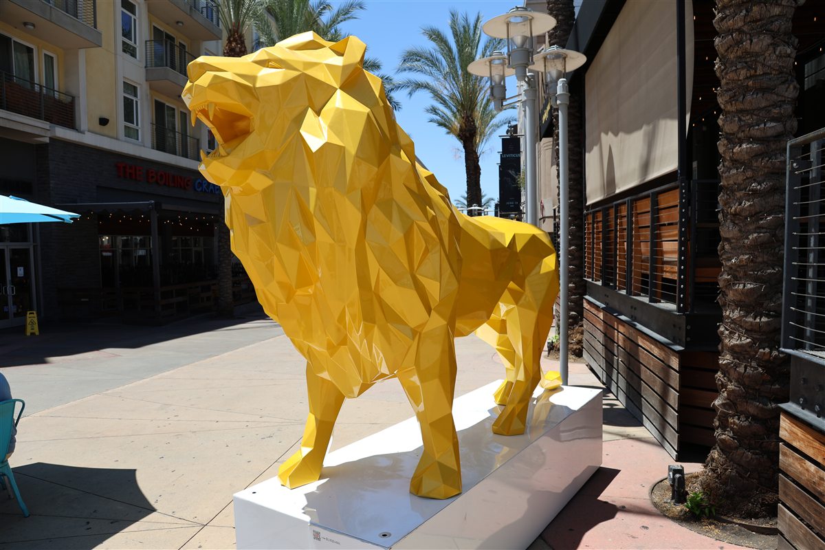Yellow lion sculpture standing on the AMC Walkway